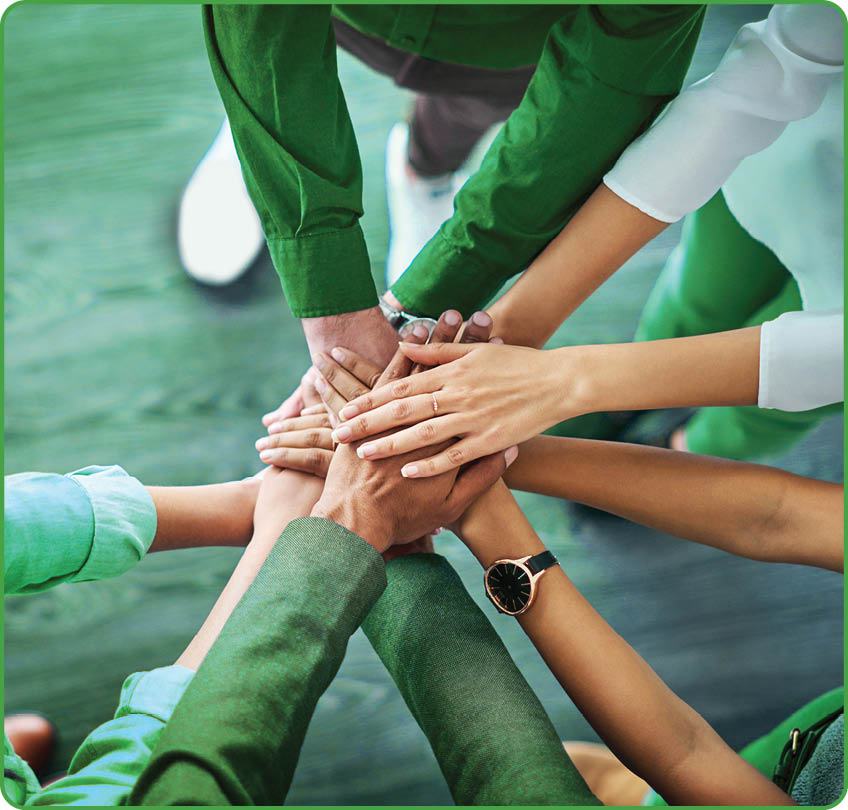 High angle shot of a group unrecognizable businesspeople joining their hands together in unity 