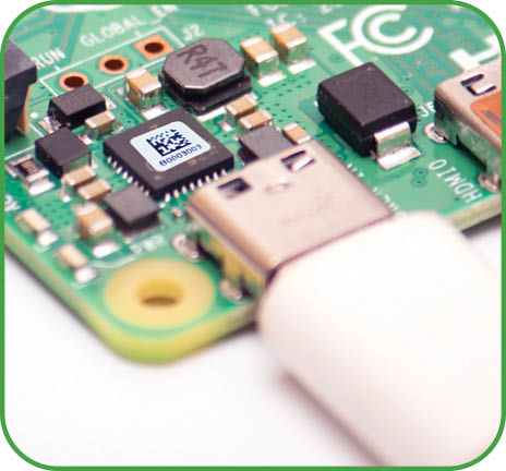 Kiev, Ukraine - August 13th, 2020: Connected to power supply by USB 3 0 type C cord SBC budget micro computer Raspberry Pi 4B  Isolated photo of RPI4B on white background 